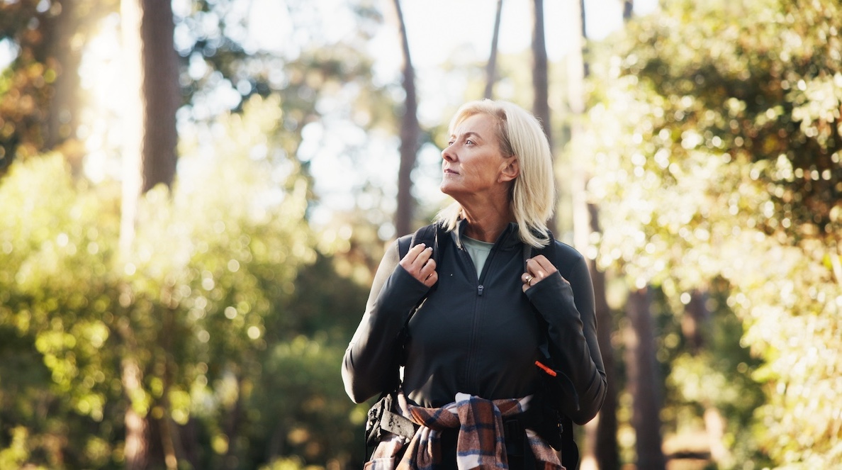 Thinking, hiking and senior woman outdoor for travel, holiday or vacation for backpacking adventure. Thoughts, trekking and old person in woods for reflection, vision or sightseeing to explore nature